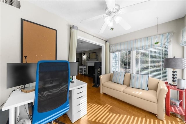 home office featuring wood finished floors and ceiling fan