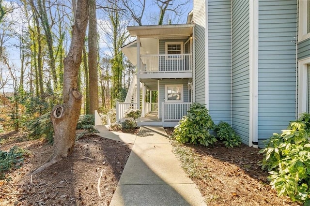 view of exterior entry with a balcony and a porch