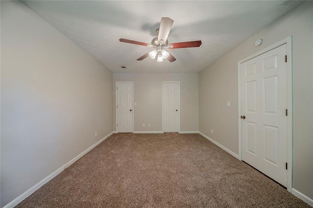 unfurnished bedroom with carpet floors, baseboards, and ceiling fan