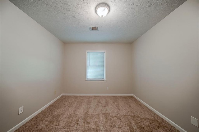 carpeted empty room with baseboards, a textured ceiling, and visible vents