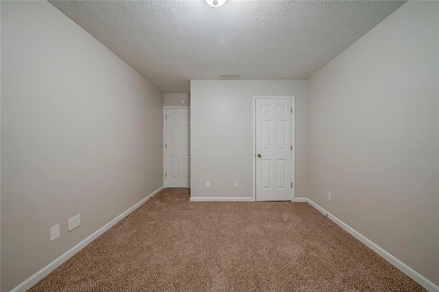 unfurnished bedroom featuring a textured ceiling, light colored carpet, and baseboards