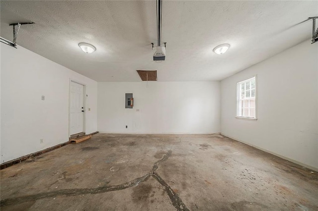 garage with baseboards and electric panel