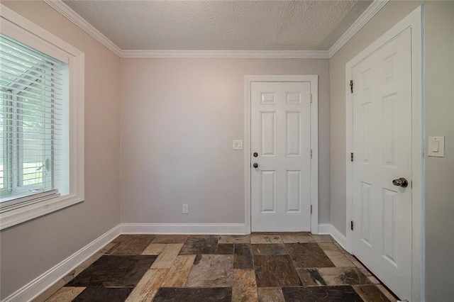 entrance foyer featuring baseboards, stone tile floors, a textured ceiling, and ornamental molding