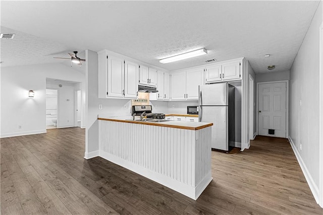 kitchen with wood finished floors, ceiling fan, stainless steel appliances, under cabinet range hood, and visible vents