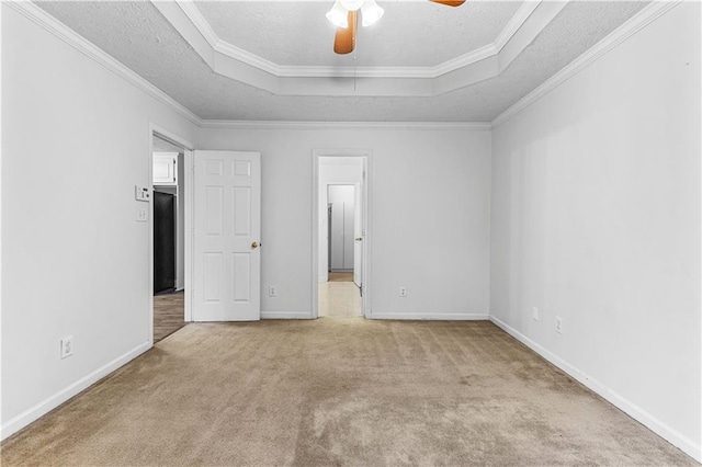unfurnished bedroom with a raised ceiling, a textured ceiling, and carpet