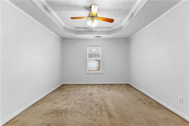 unfurnished room with a tray ceiling, visible vents, baseboards, ceiling fan, and carpet floors