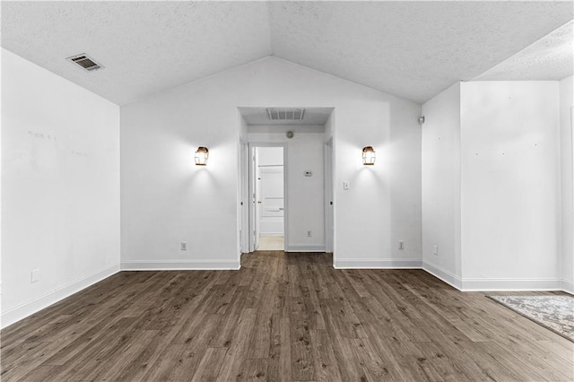 unfurnished room featuring a textured ceiling, wood finished floors, visible vents, and lofted ceiling