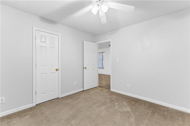 unfurnished bedroom with baseboards, carpet floors, a textured ceiling, and ceiling fan
