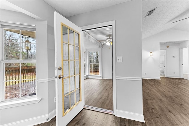 entryway with wood finished floors, visible vents, a ceiling fan, baseboards, and a textured ceiling