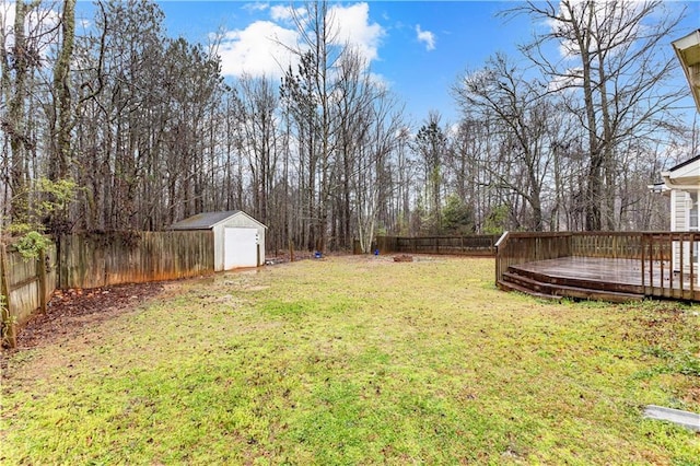 view of yard with a fenced backyard, an outdoor structure, a deck, and a storage shed