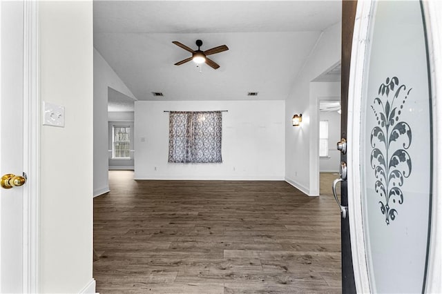 unfurnished living room with lofted ceiling, baseboards, dark wood-style floors, and ceiling fan