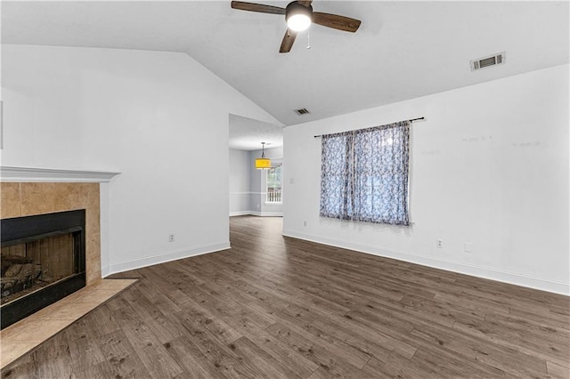 unfurnished living room with ceiling fan, wood finished floors, visible vents, and a tiled fireplace