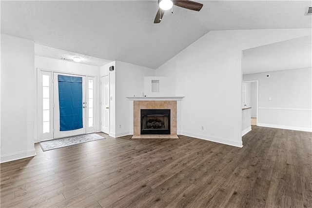 unfurnished living room featuring a fireplace, vaulted ceiling, a ceiling fan, and dark wood-style floors