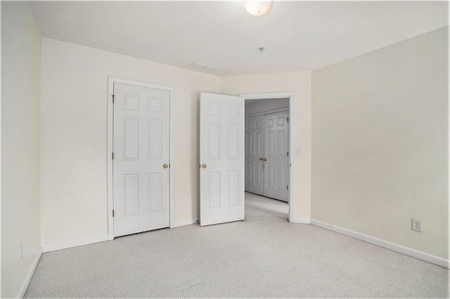 unfurnished bedroom featuring light carpet