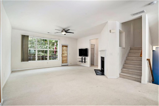 unfurnished living room featuring ceiling fan and light colored carpet