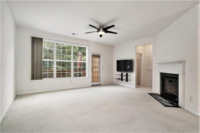 unfurnished living room featuring ceiling fan and light carpet