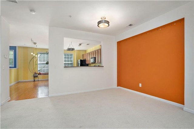 unfurnished living room featuring light colored carpet