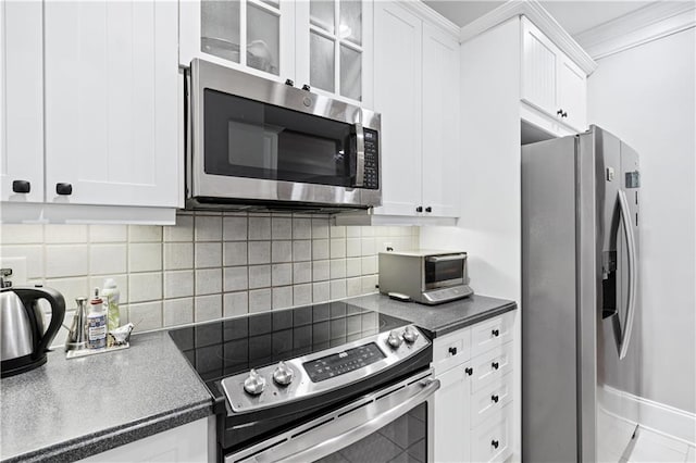 4100 Paces Walk SE Unit 2304, Atlanta, GA 30339 - kitchen with appliances with stainless steel finishes, white cabinetry, glass insert cabinets, tasteful backsplash, and ornamental molding