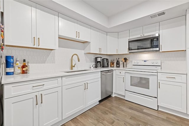 3236 Henderson Mill Rd Unit 1, Chamblee, GA 30341 - kitchen featuring stainless steel appliances, white cabinets, light countertops, and tasteful backsplash