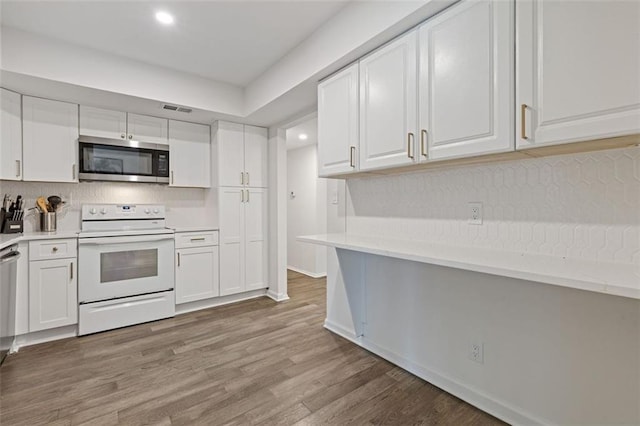 3236 Henderson Mill Rd Unit 1, Chamblee, GA 30341 - kitchen with stainless steel microwave, white range with electric cooktop, white cabinets, light countertops, and light wood finished floors