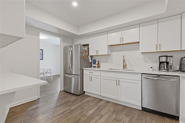 3236 Henderson Mill Rd Unit 1, Chamblee, GA 30341 - kitchen with stainless steel appliances, light wood-style flooring, white cabinets, decorative backsplash, and light stone counters