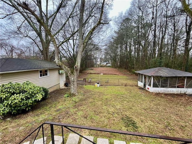 view of yard featuring a sunroom and fence