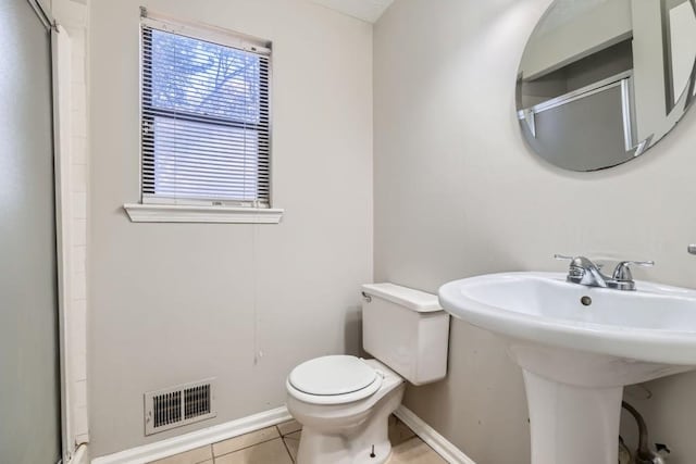 bathroom with tile patterned floors, toilet, sink, and walk in shower