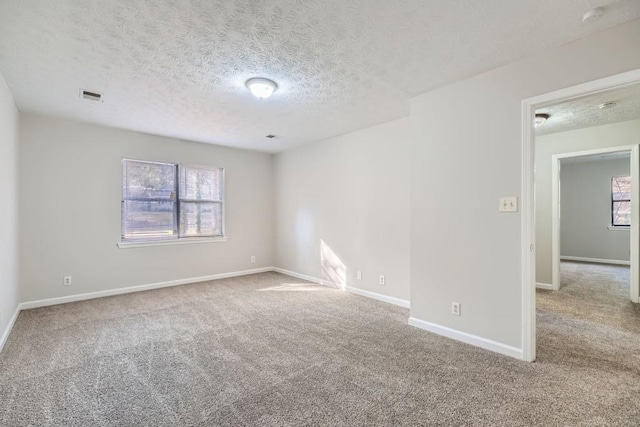 unfurnished room featuring carpet floors and a textured ceiling