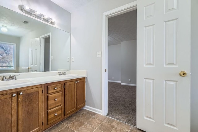 bathroom featuring tile patterned floors, vanity, and a textured ceiling