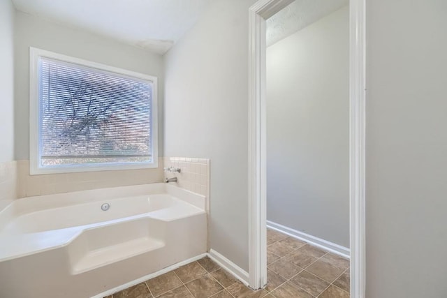 bathroom with a bath and tile patterned floors