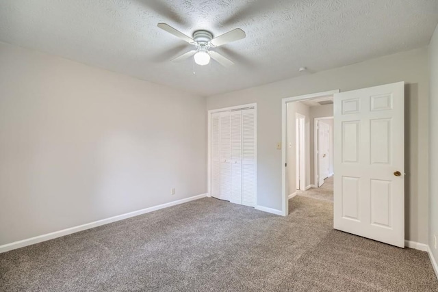 unfurnished bedroom featuring a textured ceiling, carpet floors, a closet, and ceiling fan