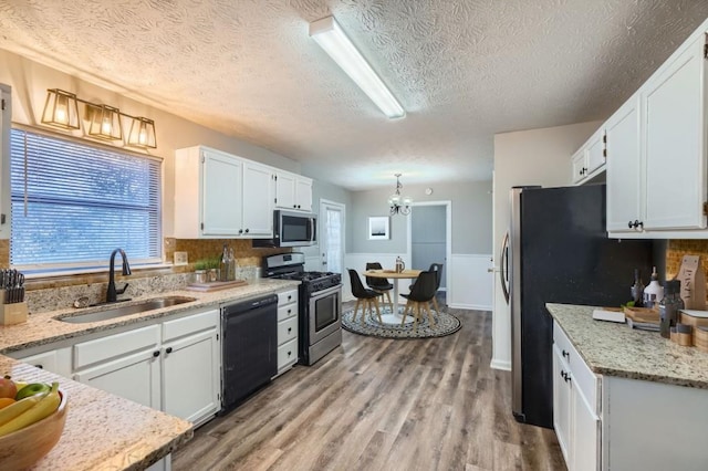 kitchen featuring a textured ceiling, stainless steel appliances, white cabinetry, and sink