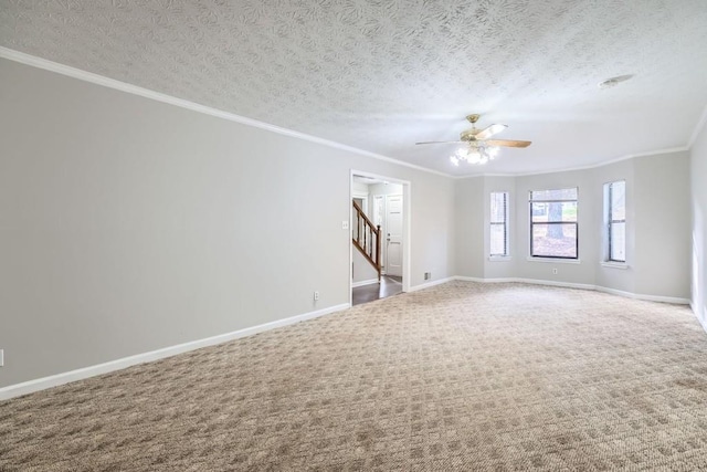 empty room with ceiling fan, crown molding, carpet floors, and a textured ceiling