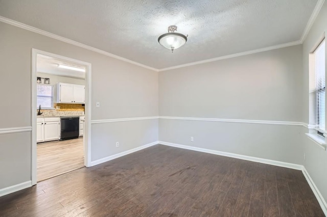 empty room with a textured ceiling, hardwood / wood-style flooring, and plenty of natural light