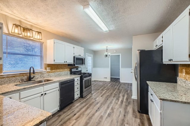 kitchen with white cabinets, sink, appliances with stainless steel finishes, and a textured ceiling