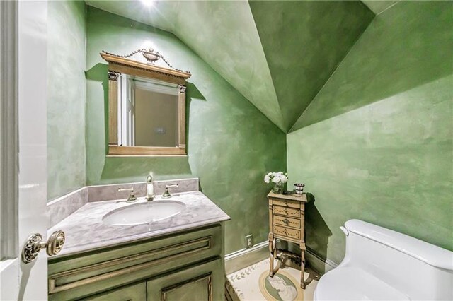 3456 Paces Pl NW, Atlanta, GA 30327 - bathroom with toilet, lofted ceiling, vanity, and wood finished floors