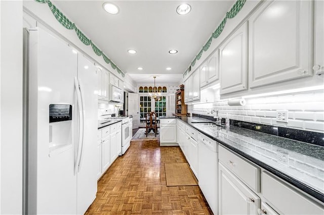 3456 Paces Pl NW, Atlanta, GA 30327 - kitchen with white appliances, a sink, white cabinets, a chandelier, and recessed lighting