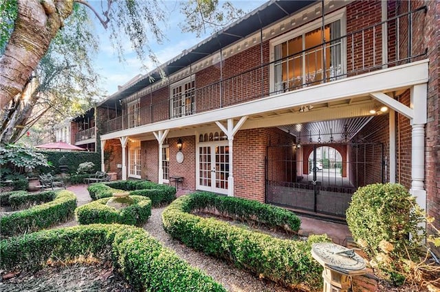 3456 Paces Pl NW, Atlanta, GA 30327 - view of home's exterior with brick siding, french doors, a balcony, and a patio area