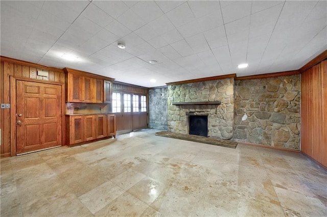 3456 Paces Pl NW, Atlanta, GA 30327 - unfurnished living room featuring wood walls, a stone fireplace, and ornamental molding
