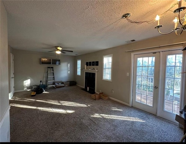 unfurnished living room featuring ceiling fan, carpet, and a textured ceiling