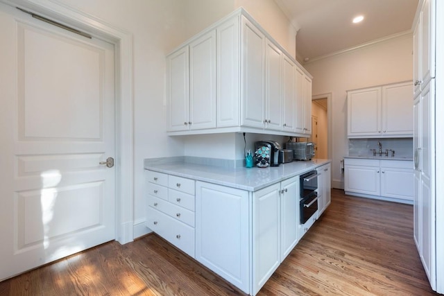 kitchen with white cabinetry, light countertops, and wood finished floors