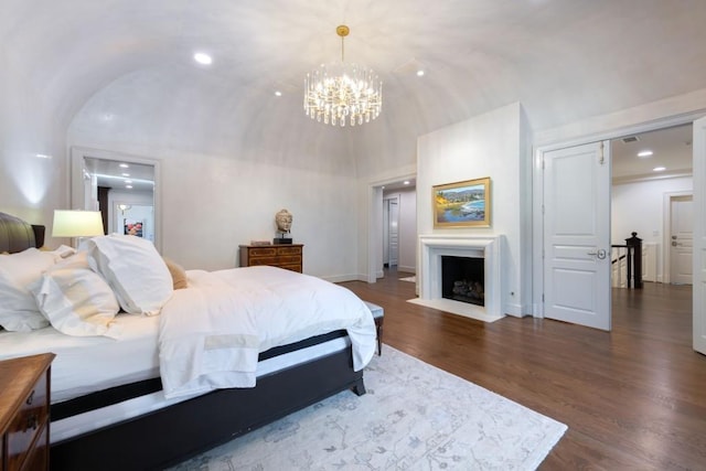 bedroom featuring a fireplace with flush hearth, dark wood-style floors, recessed lighting, baseboards, and vaulted ceiling