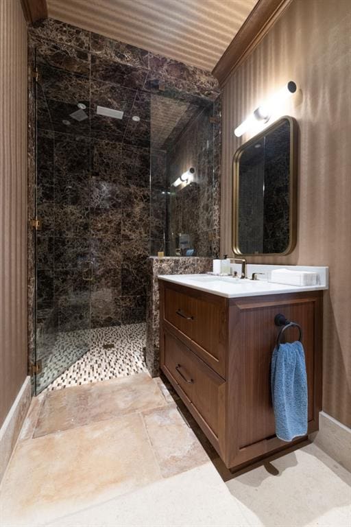 bathroom with tiled shower and vanity