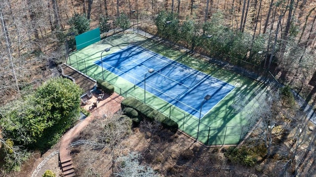 view of tennis court with an outbuilding and fence