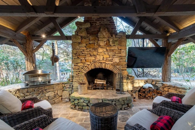 view of patio / terrace featuring exterior kitchen, an outdoor living space with a fireplace, and grilling area