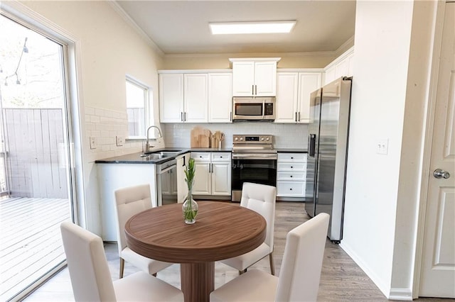 kitchen featuring crown molding, appliances with stainless steel finishes, sink, and white cabinets