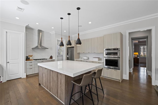 kitchen featuring visible vents, modern cabinets, stainless steel appliances, wall chimney exhaust hood, and light countertops