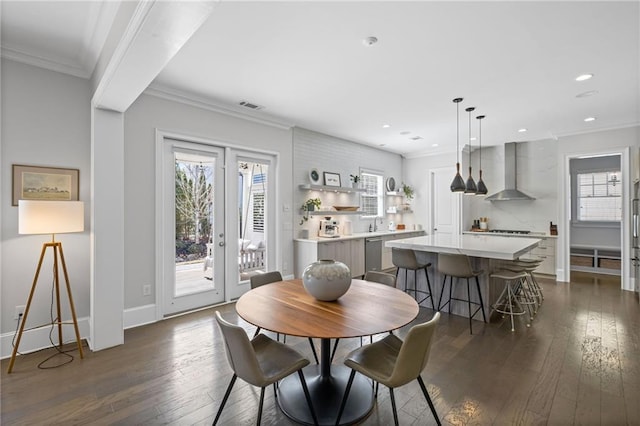 dining room featuring a healthy amount of sunlight and ornamental molding