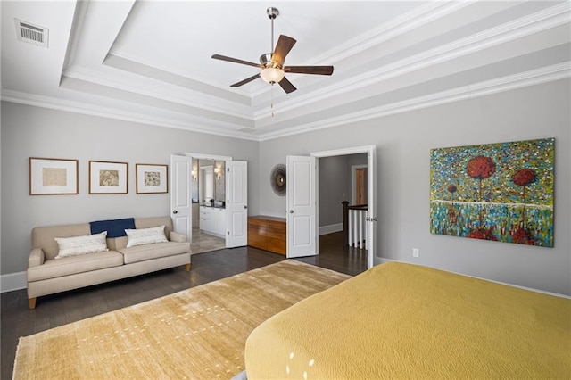 bedroom with visible vents, baseboards, a tray ceiling, ornamental molding, and dark wood-style floors