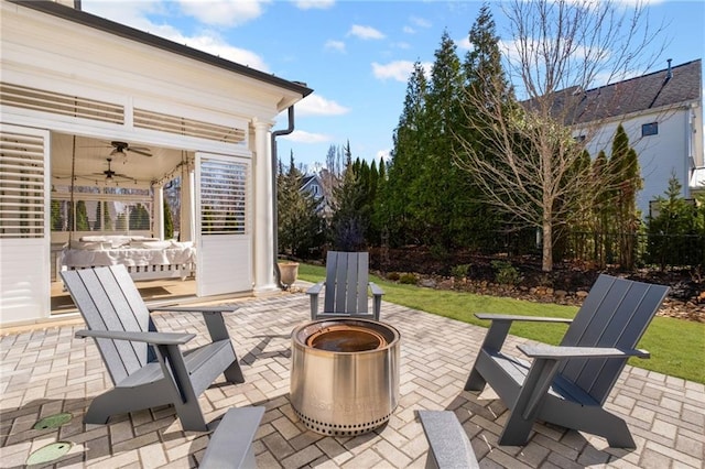 view of patio with ceiling fan and an outdoor fire pit